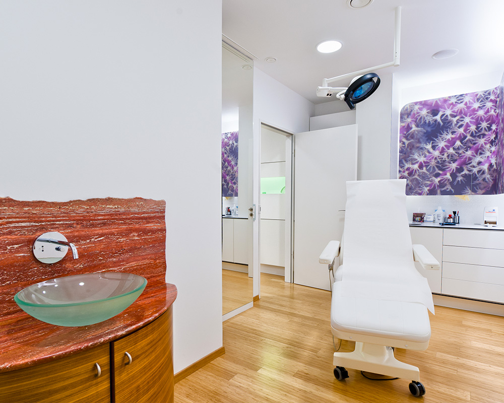 Heller und moderner Behandlungsraum der Sophienklinik Stuttgart mit Untersuchungsliege, Waschbereich und medizinischem Equipment – ein diskreter Ort für Beratungen und Eingriffe im Bereich der Intimchirurgie.